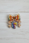 An acrylic bow and bead set with beige edges and colorful seahorse illustrations, featuring a smaller multicolored seahorse bead