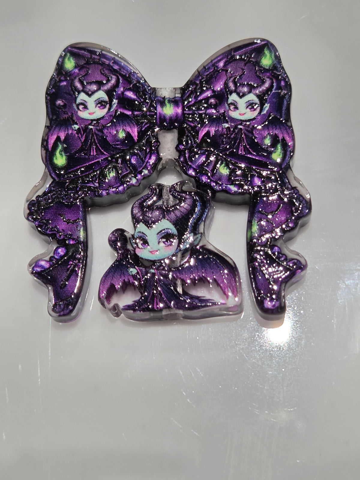 An acrylic bow and bead set in purple and black and green 