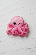 A pink octopus bead with a winking face.