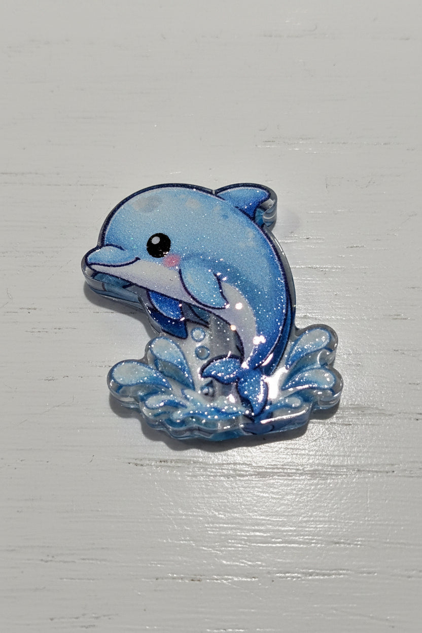 A small blue dolphin bead with glittery blue and white coloring.