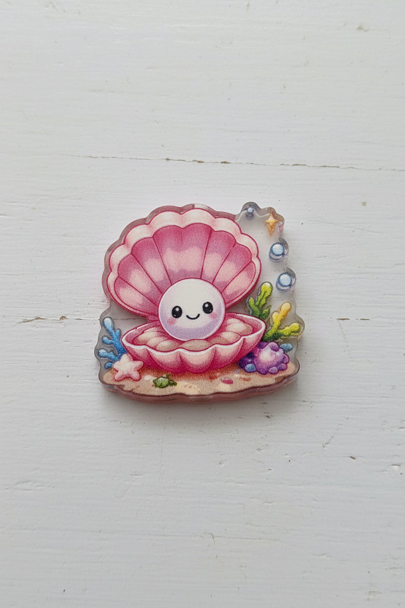A small decorative shell-shaped bead with a smiling pink and white clam design, surrounded by tiny colorful sea-themed details.