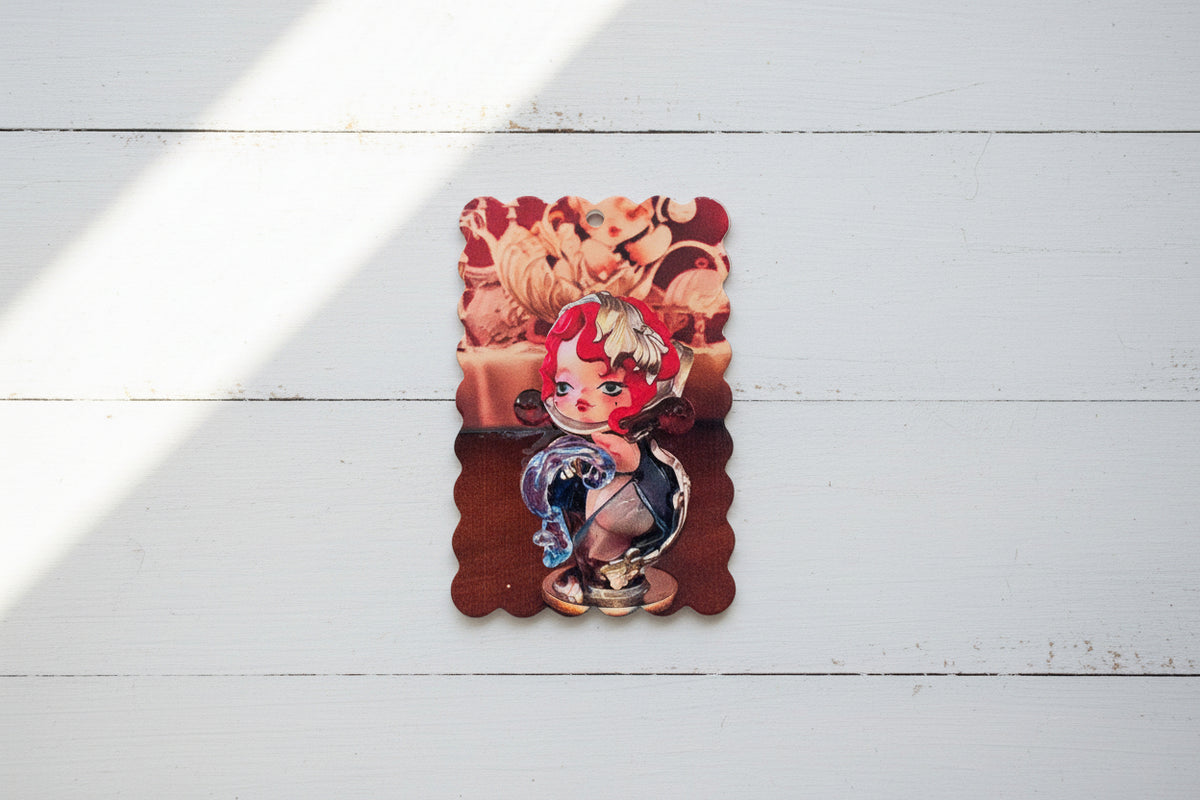 An acrylic tag featuring an anime-style character with red and white hair, set against a warm-toned background.