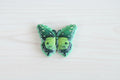 A green butterfly-shaped acrylic bead with black and white spotted wing patterns.