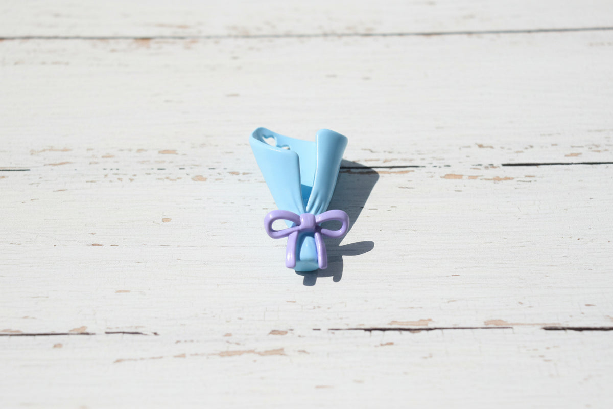 A small light blue and purple shaped like a  bouquet with a bow.