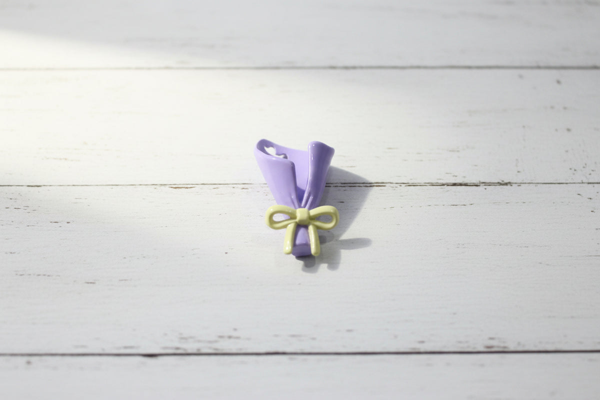 A small lavender and pale yellow bouquet bead with heart-shaped cutouts