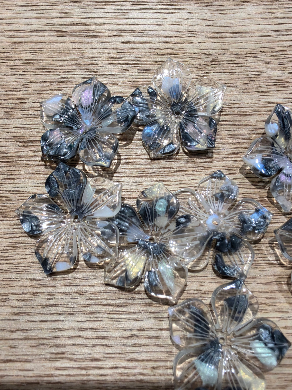 Flower-shaped beads with iridescent blue, purple.