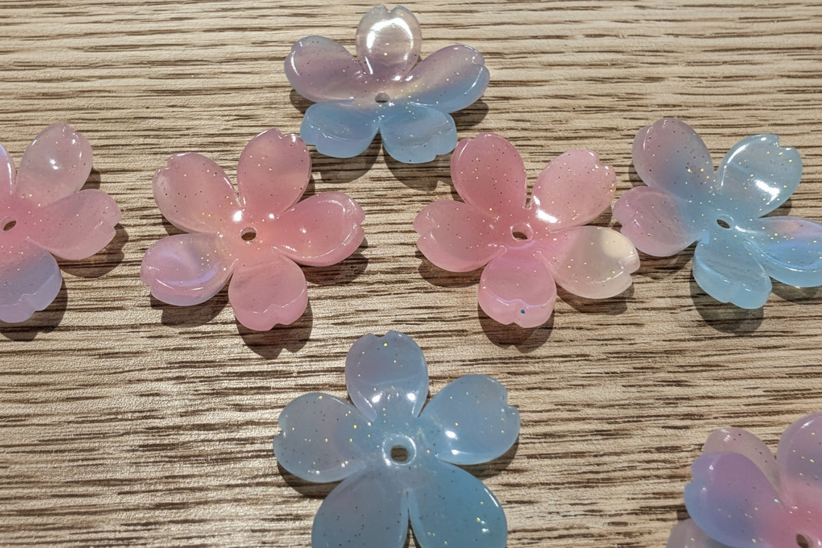 Flower-shaped beads with five petals, shown in pastel pink and light blue.