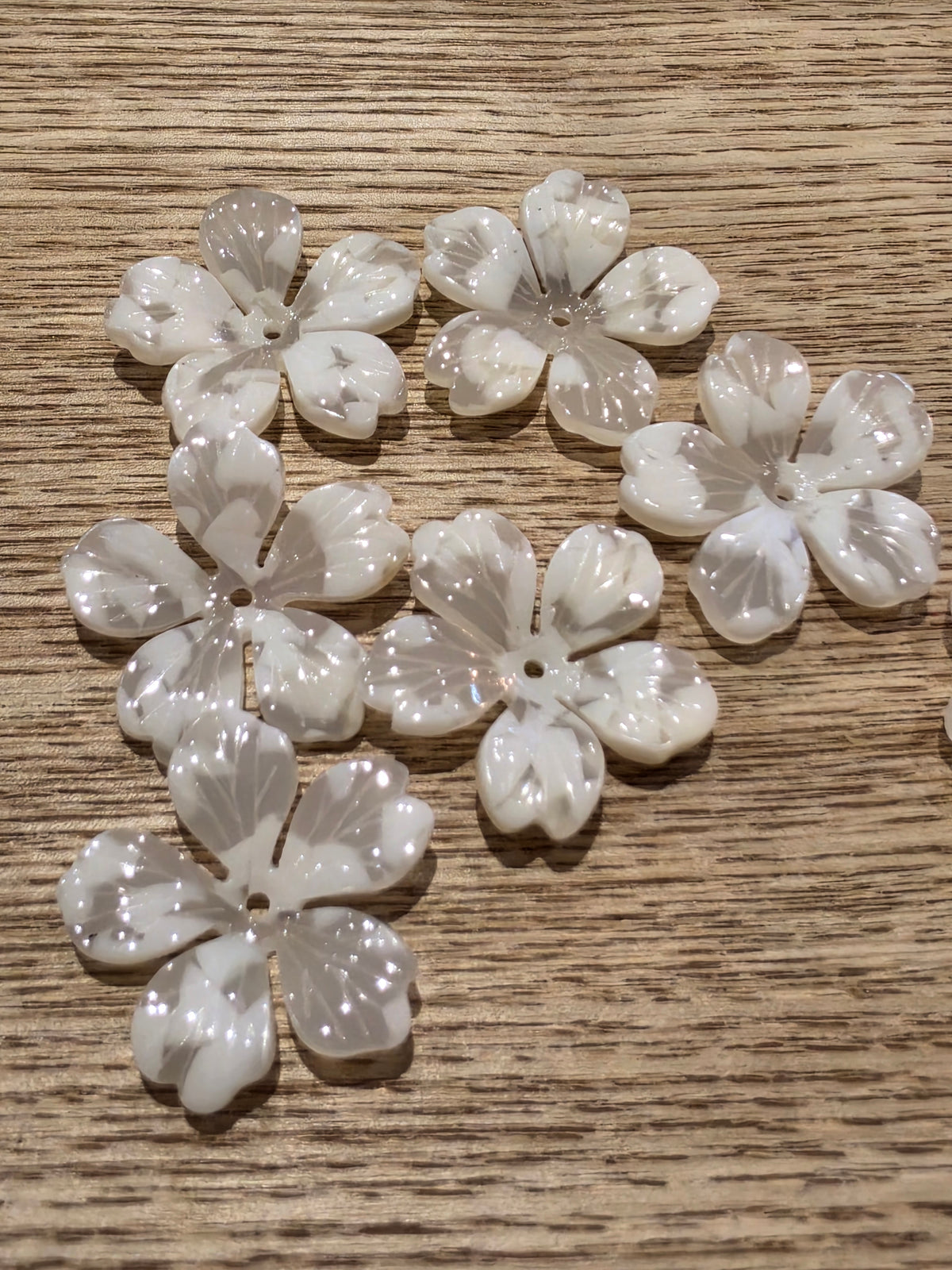 White flower-shaped beads with a glossy finish.