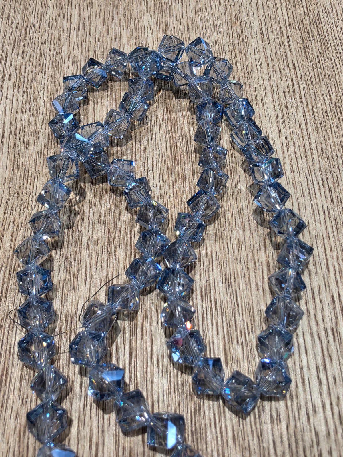 Light grey/blue glass crystal beads on a string.