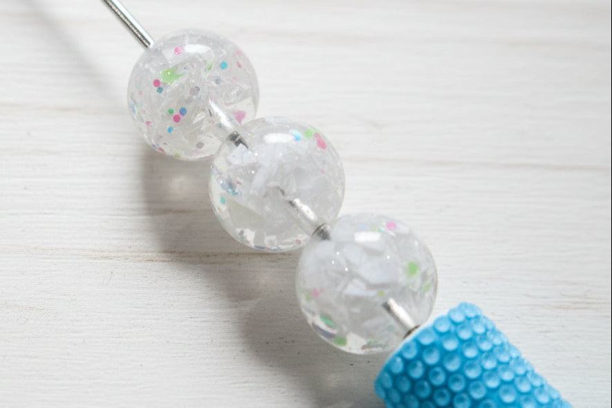 16mm white resin round beads filled with white glitter and small multicolored flecks.