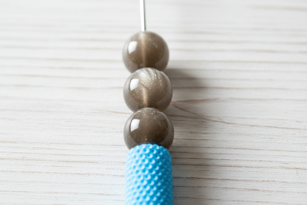 A close-up of glossy brown-grey round resin beads.