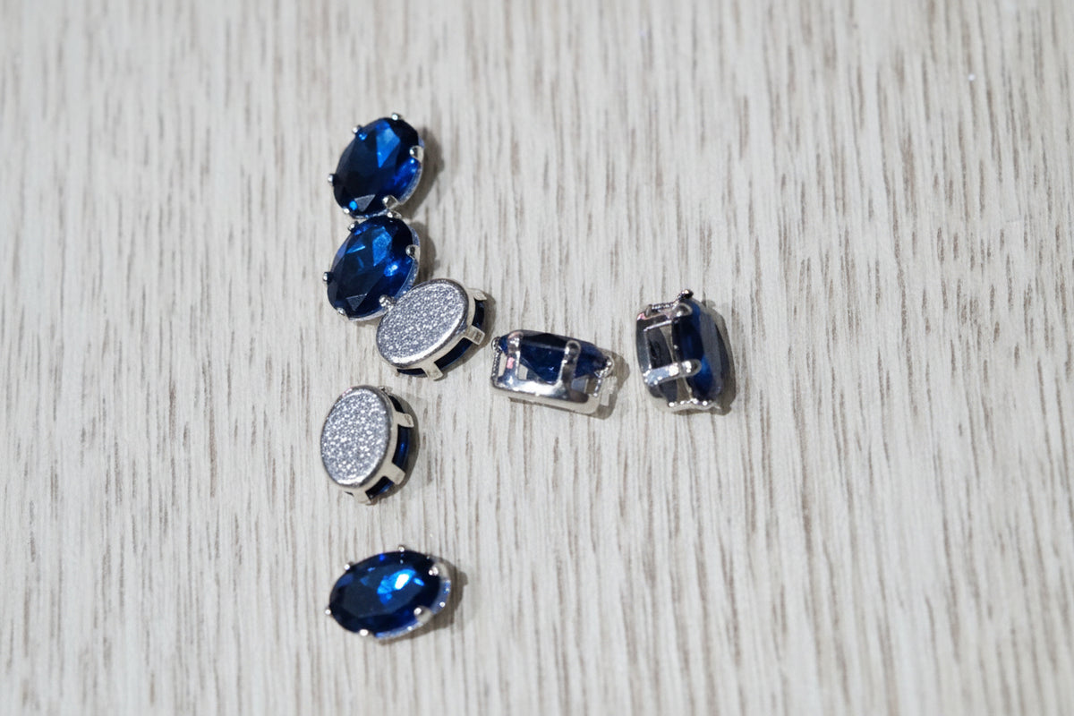 blue oval zircon beads  arranged on a wood-grain surface