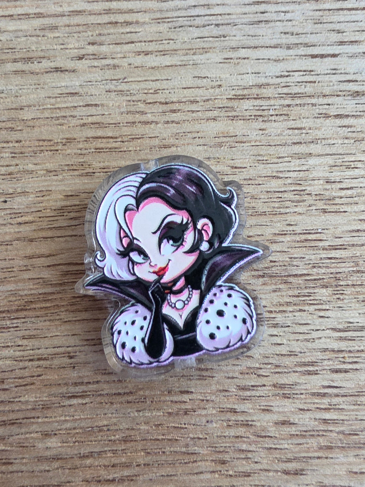 An acrylic bead featuring a lady in black and white clothes