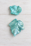 Light blue acetate leaves with a hole displayed on a white background.