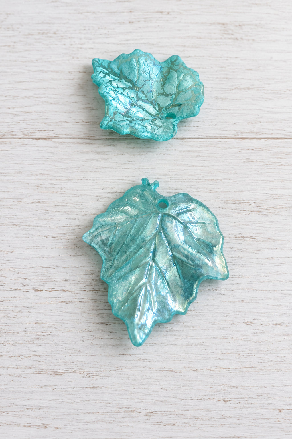 Light blue acetate leaves with a hole displayed on a white background.