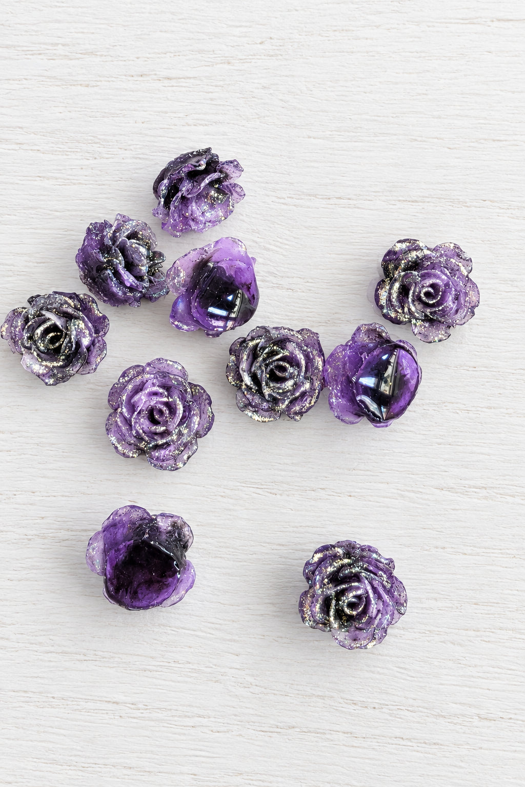 Small purple rose-shaped beads with glittery silver edges