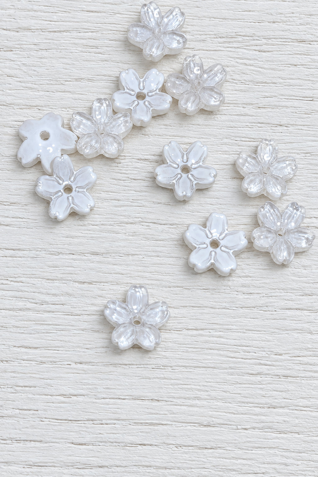 Small white glass flower-shaped beads with a central hole.