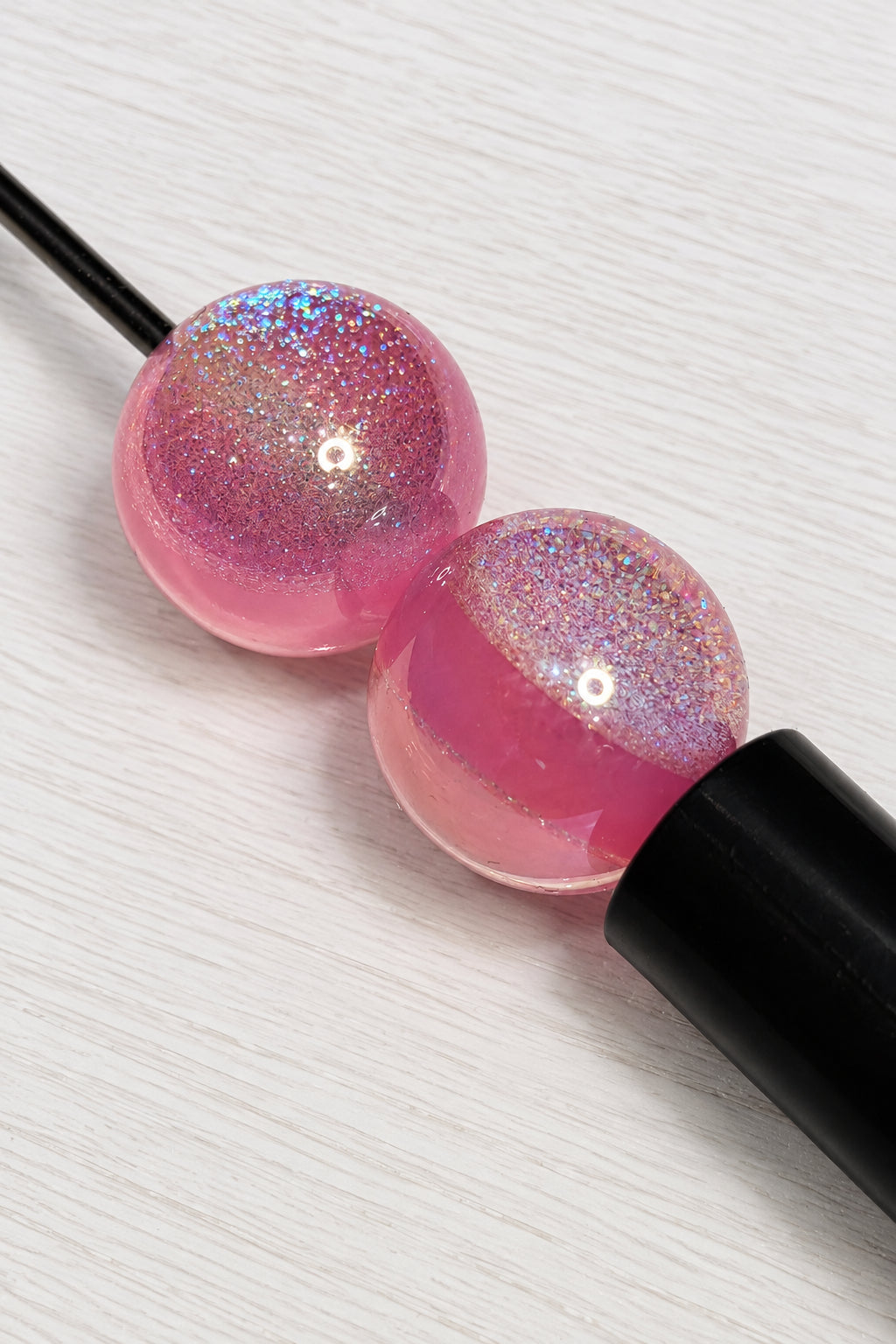 16mm pink resin beads placed on a pen