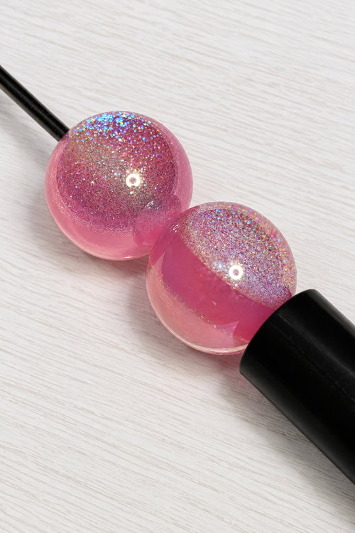 16mm pink resin beads placed on a pen