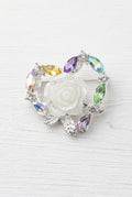 A heart-shaped silver-toned bead featuring a central white rose surrounded by iridescent zircon accents.