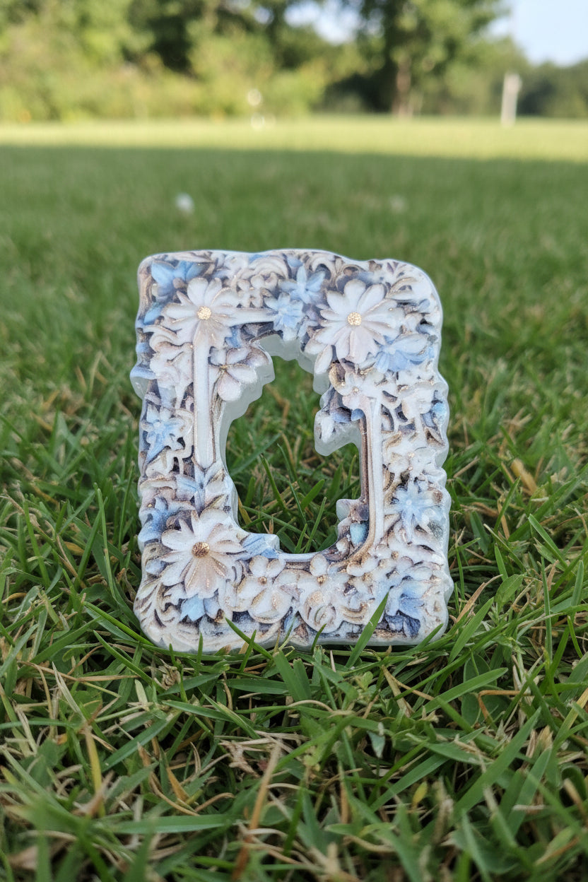 A decorative rectangular acrylic frame bead  with an ornate floral pattern in white, light blue