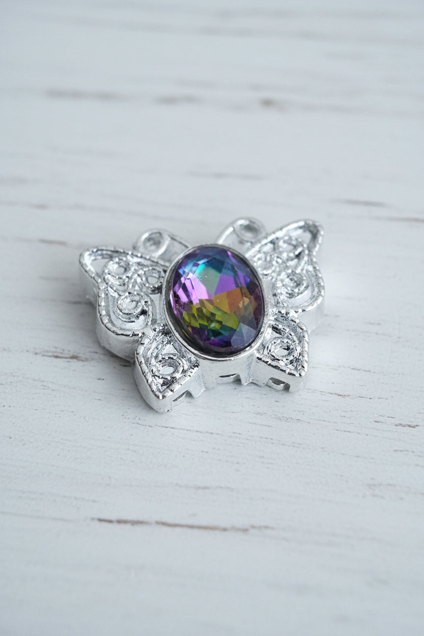 A silver-toned filigree bead featuring a prominent oval-cut galaxy glass crystal in the center.
